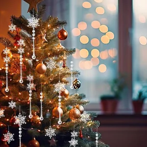 Sparkling clear acrylic snowflake and teardrop ornaments on a glowing Christmas tree