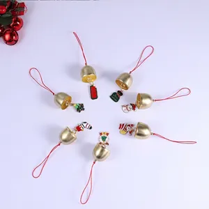 Détail de cloches de Noël dorées avec breloques en émail coloré et boucles rouges