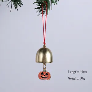 Détail d'une cloche en métal avec citrouille d'Halloween suspendue à une branche
