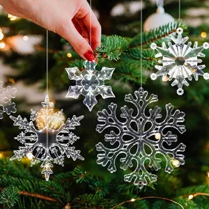 Close-up of transparent acrylic snowflake ornaments hanging on a festive Christmas tree.
