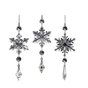 Detailed view of three clear acrylic snowflake ornaments with faceted crystal designs