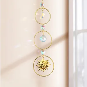 Detailed macro view of a suncatcher featuring golden moon, sun, and crystal teardrop