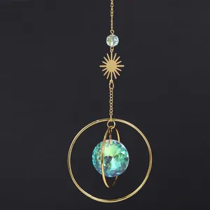 Dettaglio acchiappasole con sfera di cristallo iridescente e ornamento in metallo dorato