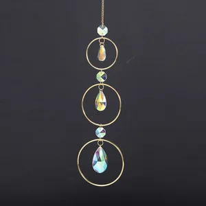Triple ring crystal suncatcher with iridescent teardrop prisms and golden accents.