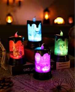 Close-up detail of four colorful LED Halloween candles with pumpkin and skull motifs
