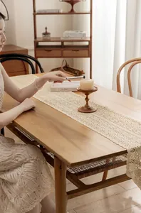 Close-up detail of hollow lace cotton crochet table runner in retro rustic country style