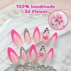 Detail view of handmade almond press-on nails with pink French tips and 3D flowers