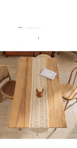 Detail of a vintage cream crochet lace table runner on a rustic wooden dining table.