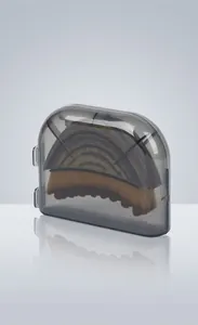 Detail van gezichtsmassageborstel met grijze transparante beschermende koffer voor reizen