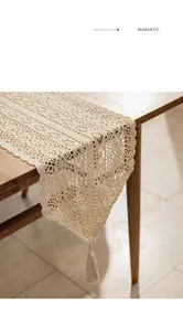 Close-up of beige crochet lace table runner with intricate hollow floral patterns