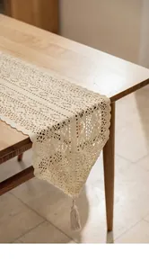 Nahaufnahme des beigen Häkel-Tischläufers mit aufwendigen hohlen Blumenmustern