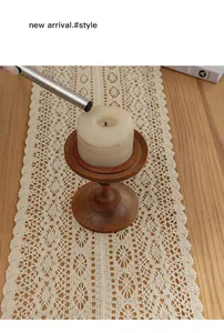 Detail view of American country style beige cotton crochet lace table runner on wooden table