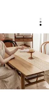 Close-up detail of a vintage beige crochet lace table runner on a rustic wooden table.