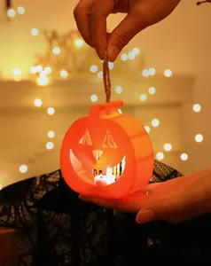 Glowing LED pumpkin lantern with warm light held by hand for Halloween party decoration