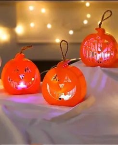 Close-up of warm glowing LED pumpkin lanterns with decorative Happy Halloween cut-out design