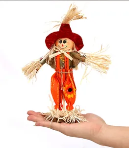 Decorative standing scarecrow figurine held in hand for autumn harvest scale