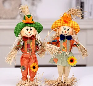 Detailed view of two cute standing harvest festival scarecrow dolls with sunflower accents.