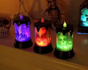 Three colorful Halloween LED candles with skull and pumpkin designs for holiday decor.