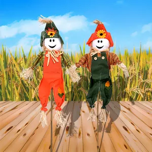 Set of two decorative Halloween scarecrows with smiling faces in an outdoor farm setting
