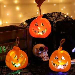 Set of three glowing orange LED pumpkin lanterns with hemp ropes for Halloween party decor