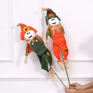 Halloween smiling face scarecrow decorations with straw limbs and festive overalls