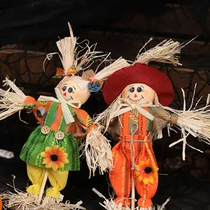 Pair of standing Halloween scarecrow ornaments with sunflower accents on spider web background