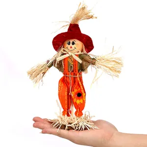 Standing harvest scarecrow ornament decoration held in hand for scale comparison