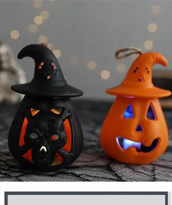 Atmospheric close-up of Halloween lighted pumpkin and skull lanterns with witch hats decor.