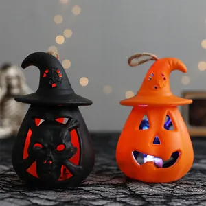 Pair of Halloween pumpkin and skull lanterns with glowing LED lights and wizard hats