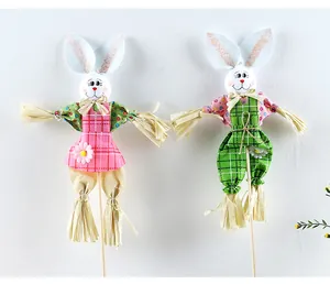 Par de lindos espantapájaros de conejo de Pascua con trajes de cuadros de colores.