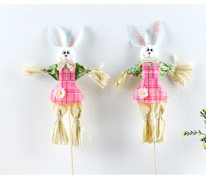 Un par de lindos espantapájaros de conejo de Pascua con delantales rosas y extremidades