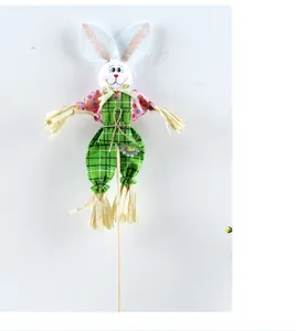 Detalle espantapájaros conejo de Pascua artesanal con mono de cuadros verdes