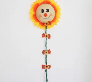 Decorazione da parete girasole sorridente con viso in iuta e fiocchi rossi