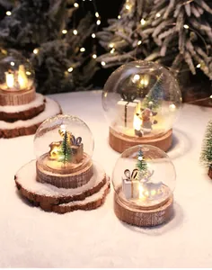 Dettaglio di palla di neve natalizia a LED con base in legno rustico