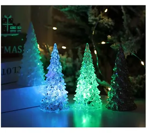 Close-up van vier LED-kerstboomornamenten die gloeien in blauw, groen en wit licht.