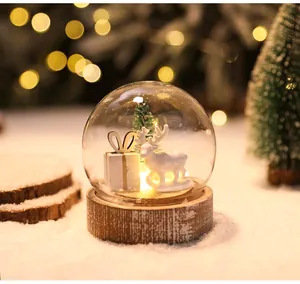 Vista dettagliata della renna bianca e della scatola regalo nella palla di neve LED