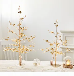 Gedetailleerd overzicht van gouden kerstbomen met LED-lampjes en witte parelkralen