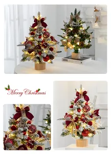 Détail d'un mini sapin de Noël enneigé avec des ornements rouges festifs et des lumières LED