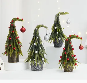 Détail de quatre mini sapins de Noël artificiels en PE avec des ornements festifs