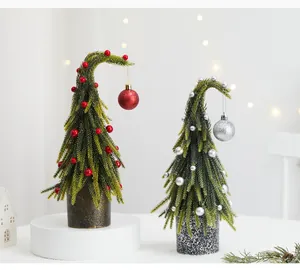 Mini arbres de Noël en PE avec des boules rouges et argentées dans une scène douillette
