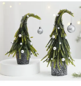 Gros plan de sapins de Noël en PE avec cimes courbées et boules argentées