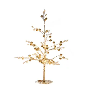 Elegante gouden kerstboom voor op tafel met edelstenen en kralen voor decoratie