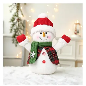 Gros plan d'un bonhomme de neige en peluche avec gilet à carreaux et bonnet de Noël