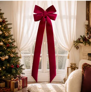 Grand nœud de Noël en velours bordeaux suspendu comme décoration de fenêtre dans un salon