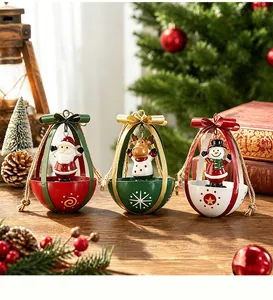 Close-up detail of three metal Christmas ornaments featuring Santa Claus, elk, and snowman