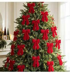 Elegant red velvet bows with long tails hanging as ornaments on a decorated Christmas tree