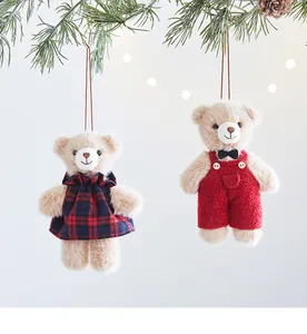 Detailed view of cute plush teddy bear Christmas ornaments hanging on a pine branch