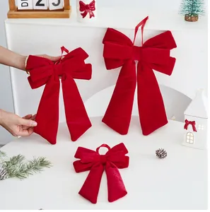 Detail of red velvet Christmas bows with long tails on a white festive background