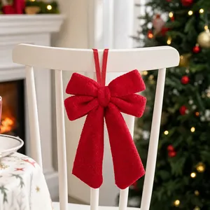 Large red velvet Christmas bow for tree and chair decoration in festive setting