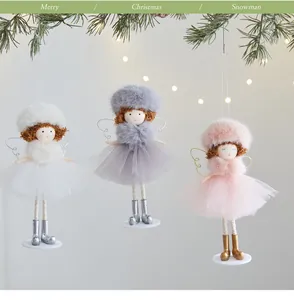 Dettaglio di tre angeli di Natale decorativi con cappelli di peluche e gonne di tulle.